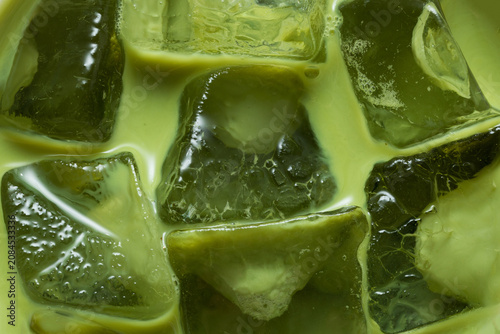 Macro Close-Up of Iced Japanese Matcha Latte with Crystal Clear Ice Cubes and Creamy Green Tea Texture