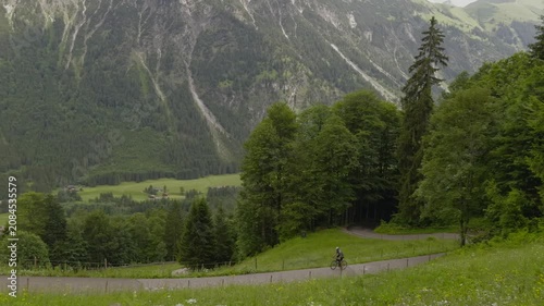 Cyclist on a drop bars road bike enjoying an epic ride and scenic cycling route on a winding paved mountain road through beautiful alpine valleys of Oberstdorf in Bavarian Alps destination