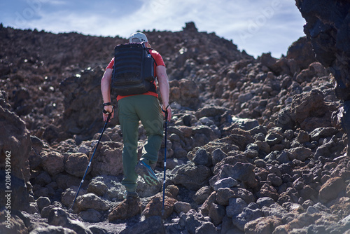 Hiker climbing rocky volcanic terrain
