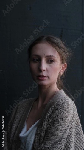 Portrait of a beautiful young girl on a dark studio background. Beautiful natural woman posing for the camera