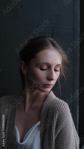 Portrait of a beautiful young girl on a dark studio background. Beautiful natural woman posing for the camera