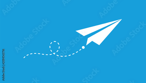 White paper airplane flying and leaving a dashed loop trail in the blue sky representing travel or messaging.