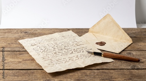 Vintage letter with fountain pen and wax seal on wooden table