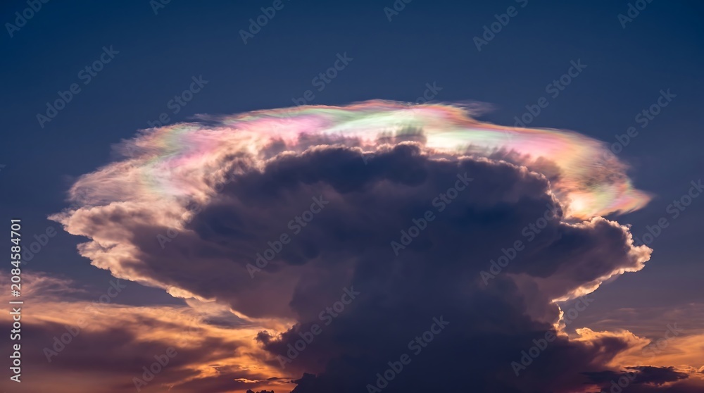 Fototapeta premium Iridescent cloud floating in sunset sky with vibrant colors