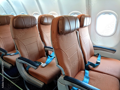Inviting commercial airplane cabin featuring empty economy seats with ample natural light from the windows, symbolizing comfort, safety, and the modern passenger flying experience