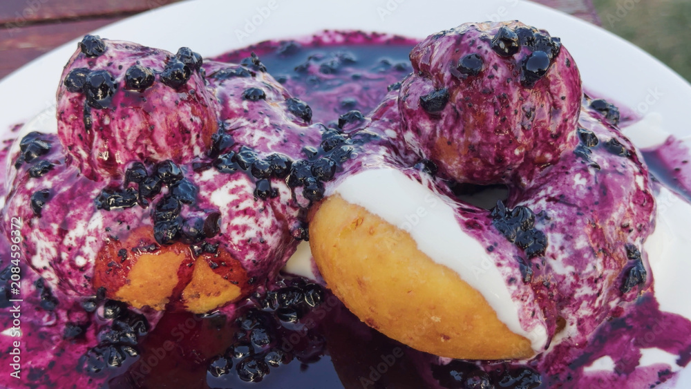 Fototapeta premium Papanasi romanian doughnuts with sour cream and blueberry jam