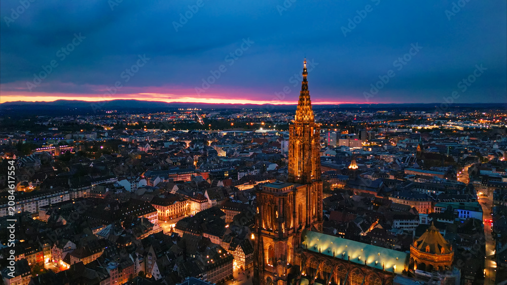 Obraz premium Strasbourg cathedral spire illuminating strasbourg city at twilight