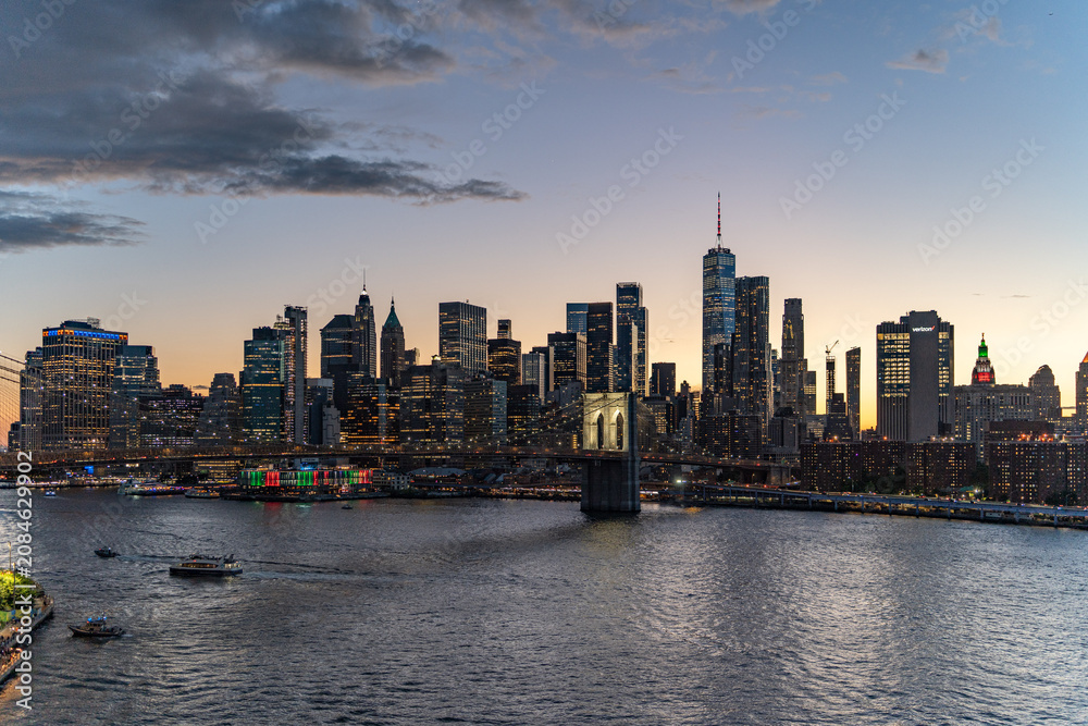 Fototapeta premium Sunset Skyline view of Lower Manhattan from an aerial view towards the Brooklyn Bridge and Financial District of New York City.