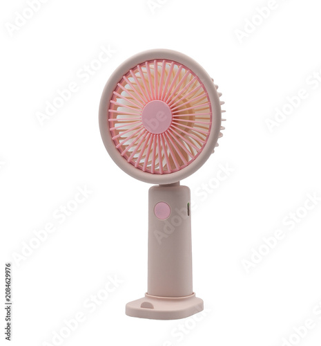 Portable pink handheld electric fan on a white background for cooling off on hot summer days