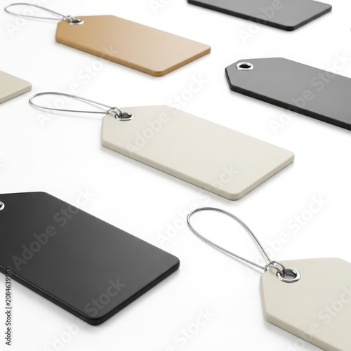 Assorted hanging tags in various colors on white background, including black, beige, and gray