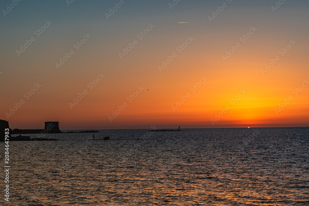 Obraz premium Trapani, lo spettacolo del tramonto, quando il sole si immerge nel mare all’orizzonte