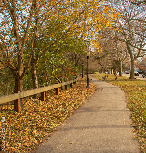 Paisaje urbano en una zona residencial de Brooklyn en otoño, New York, EEUU. Sendero junto al cruce de Burnett St. con Avenue V en Long Island.