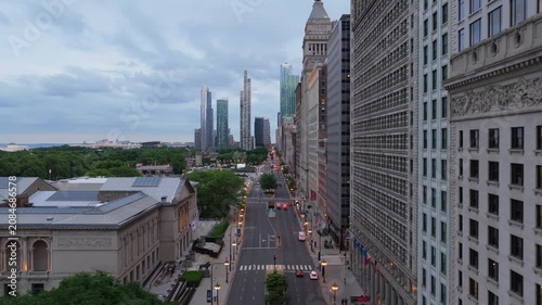 Aerial over Michigan Avenue revealing traffic and skyscrapers with Art Institute of Chicago, Millennium Park, Lake Michigan during early evening
