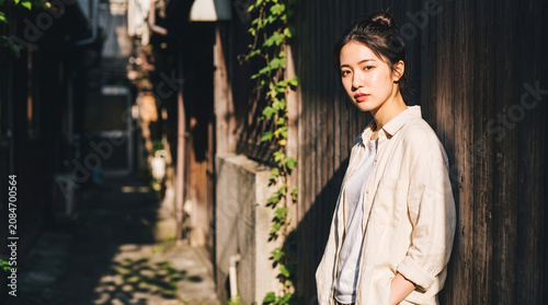 Fototapeta ノスタルジックな路地裏に佇む若い日本人女性 夏の日差しと影