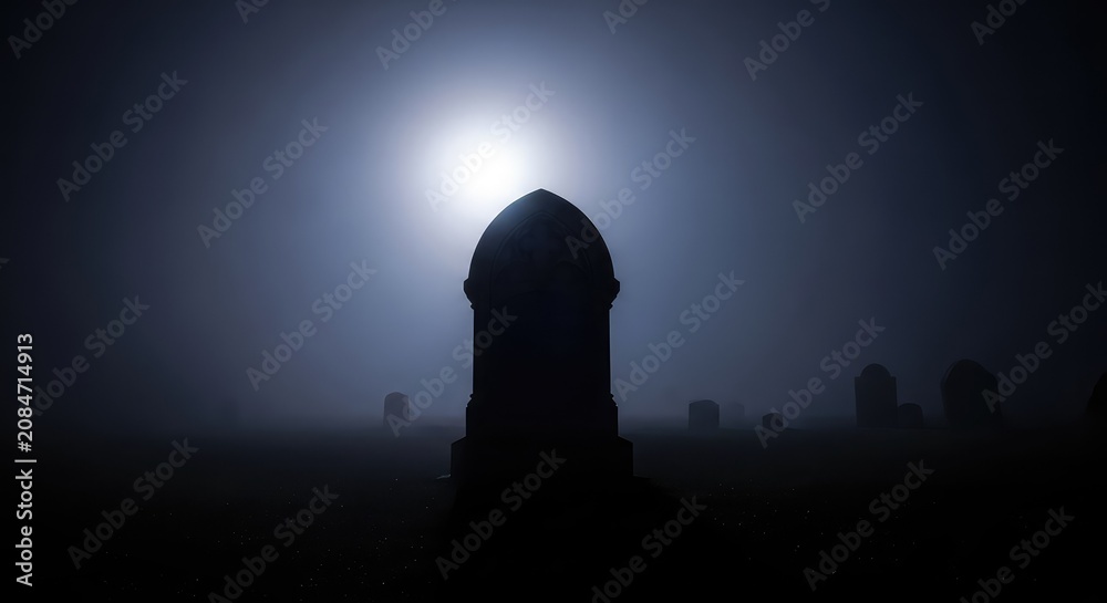 Obraz premium Dark silhouettes of ancient headstones stand amidst thick rolling fog under a bright full moon, creating a spooky and gothic night scene, scenery, silhouette, moon