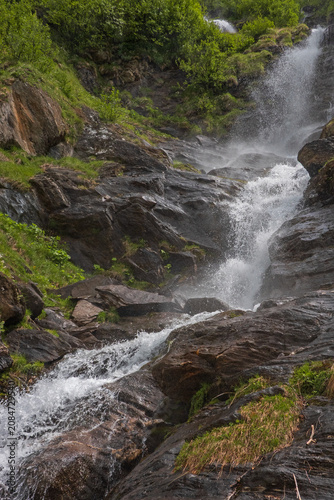 Fotografi Small waterfall, falling stepwise,  in the Swiss Alps