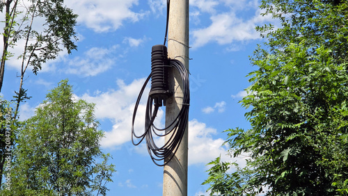 Canvas Print Fiber optic splice closure with coiled black cables mounted on a concrete utilit