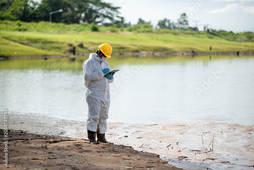 Canvastavla Environmental scientist in protective clothing examining water quality using a f