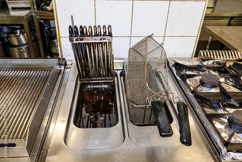 Professional kitchen tools and utensils arranged on stainless steel preparation counter