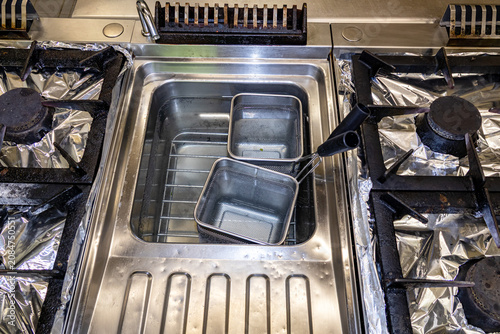 Top view of commercial deep fryer with metal baskets and equipment organization