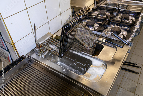 Overhead view of commercial deep fryer baskets being organized in professional kitchen station