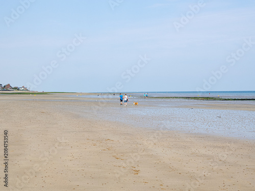 Playa de Saint-Aubin-sur-Mer, vista de la playa con mucho espacio y arena mojada sobre cielo azul, al fondo la línea del horizonte, viajando en verano 2022