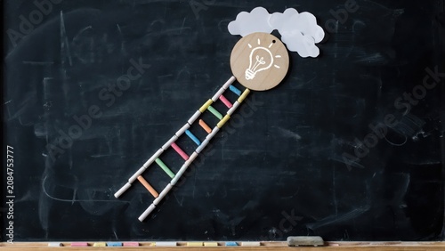 Chalk ladder reaches light bulb icon on wooden circle with clouds against blackboard in education concept.