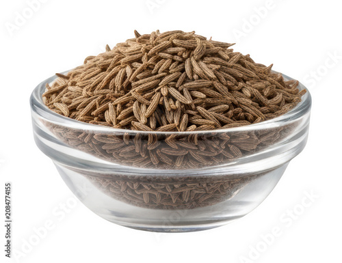 Aromatic organic brown cumin seeds overflowing from a clear glass bowl isolated transparent background image