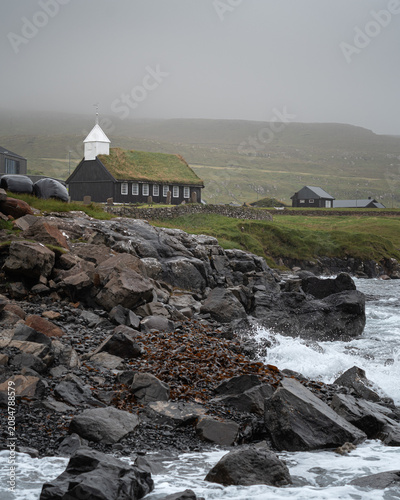 Traditional turf-roofed Kaldbak Church on the rocky coast, Faroe Islands