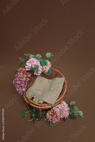 Woven Basket with Fabric and Hydrangea Flowers on Brown Surface