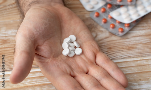 Fotografie Pills in hand top view, taking painkillers, white medical tablets