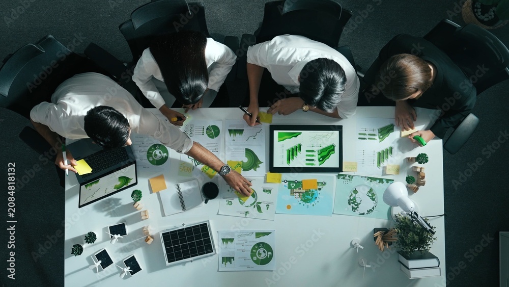 Naklejka premium Top view of executive manager hold tablet display clean energy at meeting. Aerial view of business people working together to plan and invest in sustainable environmental investment. Alimentation.