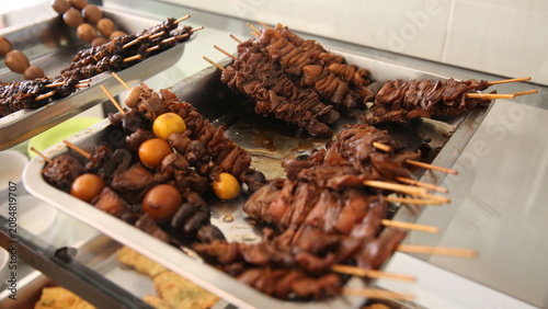 Εκτύπωση καμβά Traditional Indonesian skewered offal and braised eggs displayed on a food stall tray, authentic street food photography with rich savory appeal