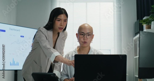Asian businesswomen sharing ideas and information during a conference. Teamwork and technology integration for successful corporate investment and strategy.