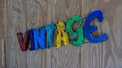 Valokuva Colorful old metal “Vintage” sign composed of individual letters on barnboard  w