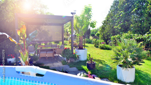 Bild auf Leinwand Outdoor swimming pool in a garden with lawn, plants and trees.