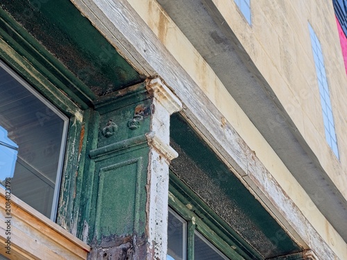 Obraz na plátně Decaying ornate ironwork details on column of former cast-iron facade building