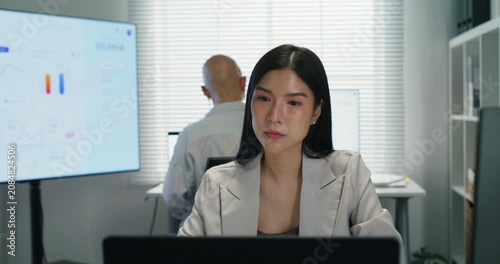 Professional Asian women discuss marketing strategy and project planning during a briefing. Teamwork and collaboration for corporate success in a modern workplace.