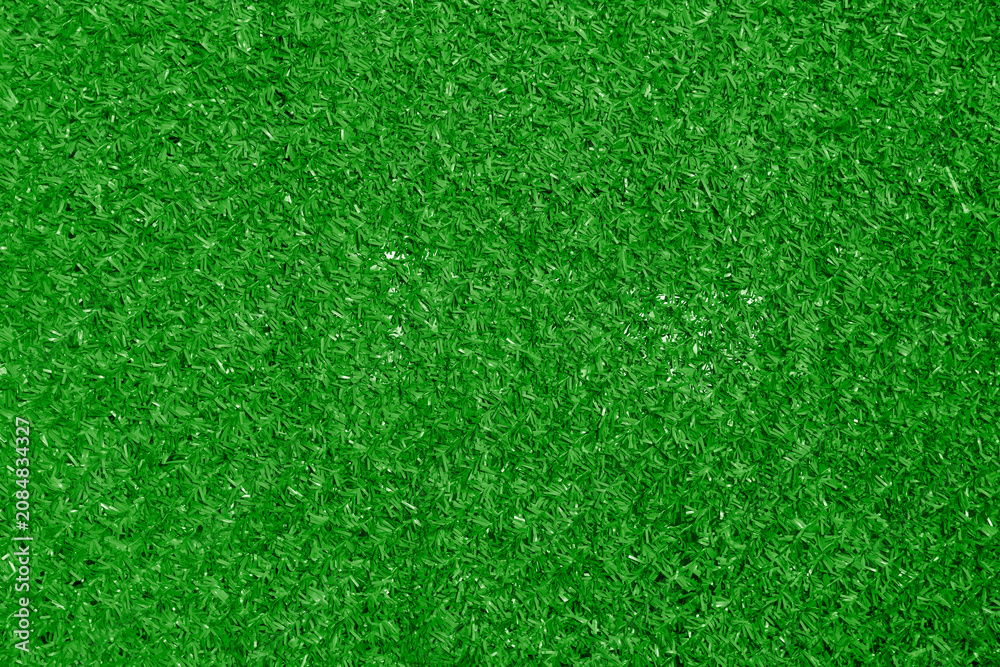 Fototapeta premium artificial plastic synthetic green grass fence close-up texture pattern background backdrop Artificial grass texture woven through a chain link fence creating a vibrant green background for design