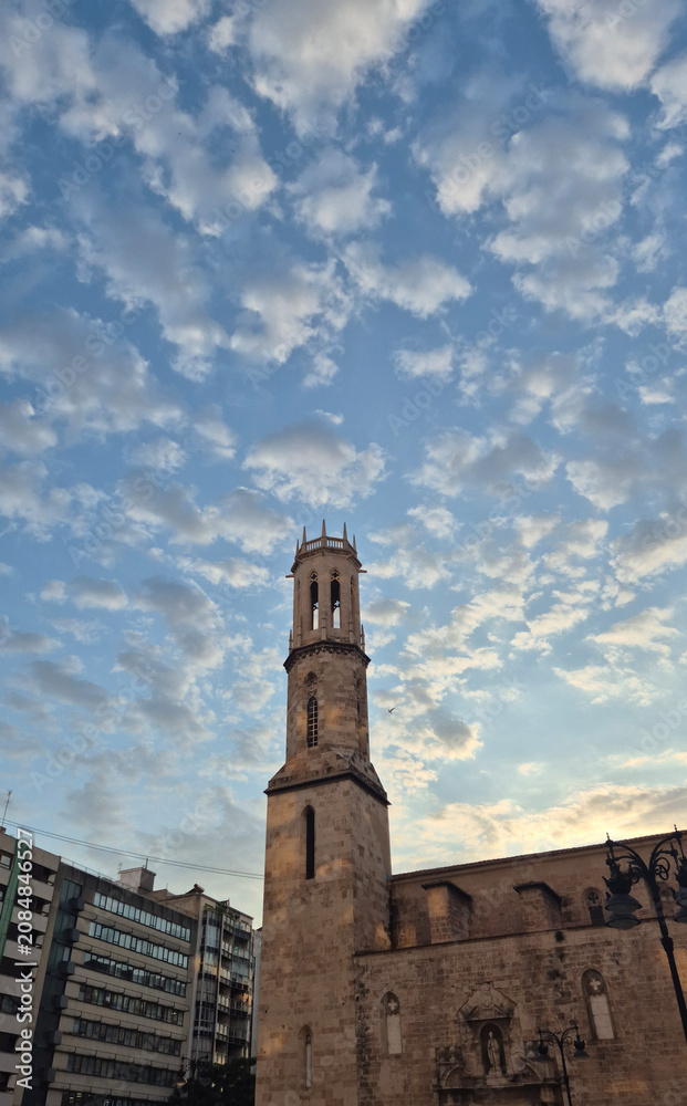 Fototapeta premium Historic stone church tower under dramatic evening sky