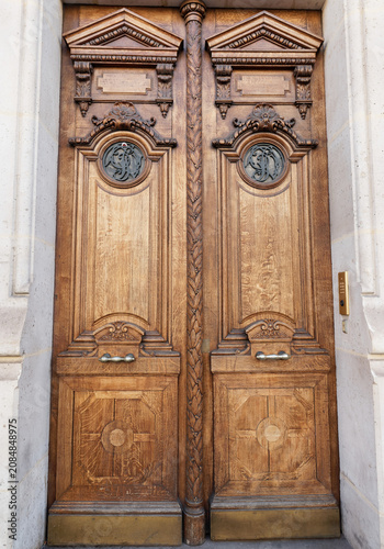 Superb close-up of an ornately carved solid oak double door on the Opera Avenue , Paris, A masterpiece of 19th-century Parisian decorative woodwork and architectural craftsmanship.