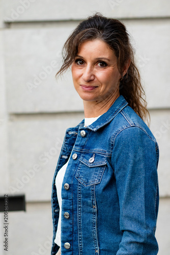 Confident mature woman smiling wearing denim jacket