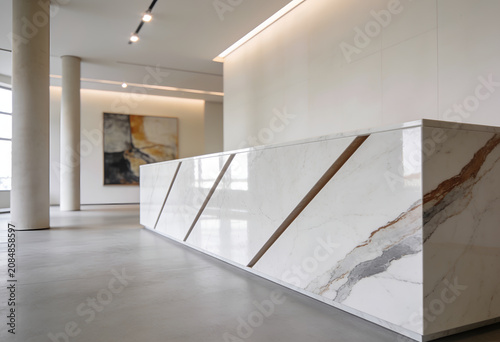 Modern white marble reception desk in a bright office lobby with art