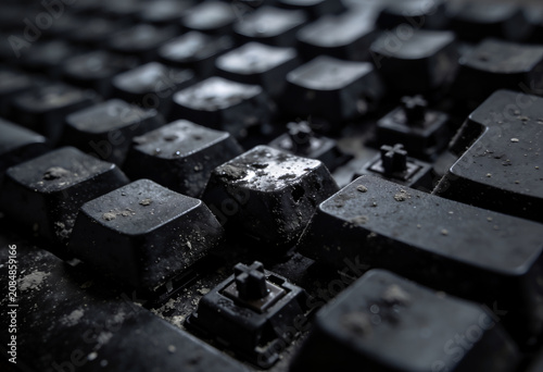 Close-up of dirty and dusty black keyboard keys with water droplets
