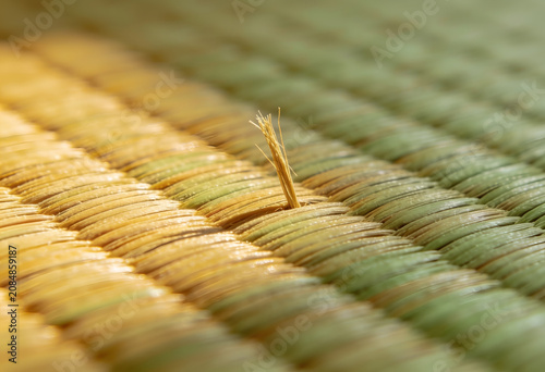 Close-up of woven natural fiber texture with protruding thread end