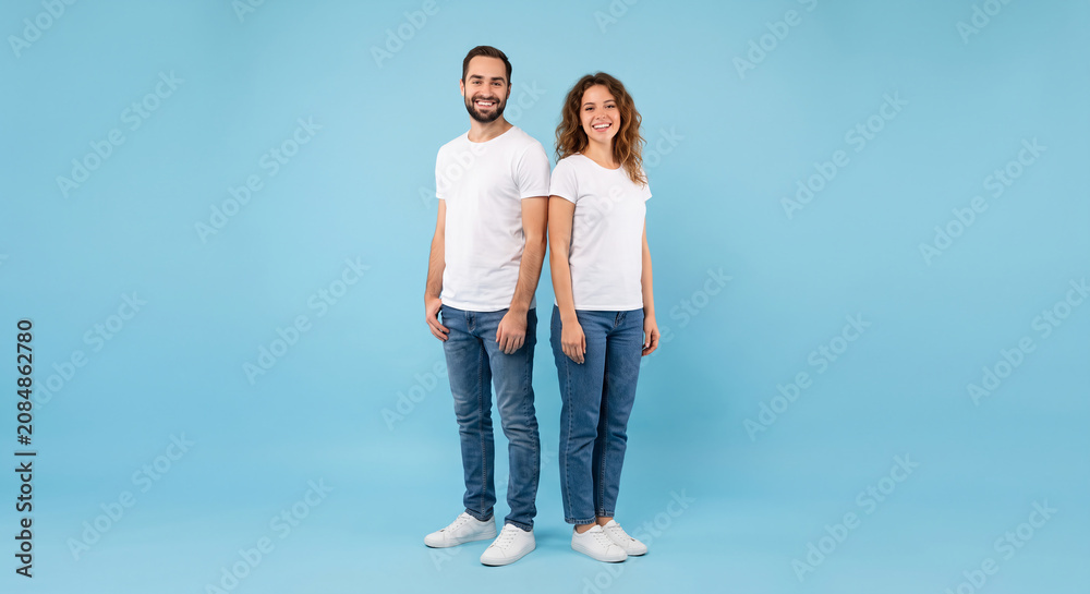 Obraz premium Happy Young Couple in White T-shirts Standing Against Blue Background in Studio