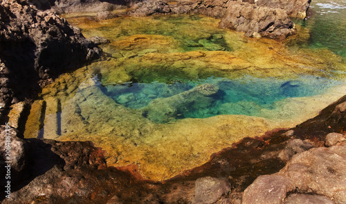 Fotografie Gran Canaria, calm rock pools under steep cliffs of the north coast are separate