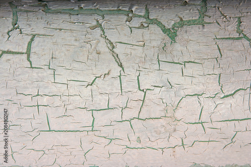 Peeling painted surface with cracked coating and aged weathered texture.