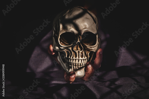 Foto Concept of memento mori with a human hand holding a skull.