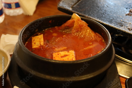Traditional Korean barbecue featuring grilled marinated meats, fresh side dishes, and a tabletop grill. Warm, inviting dining scene showcasing authentic Korean cuisine and shared meals.
